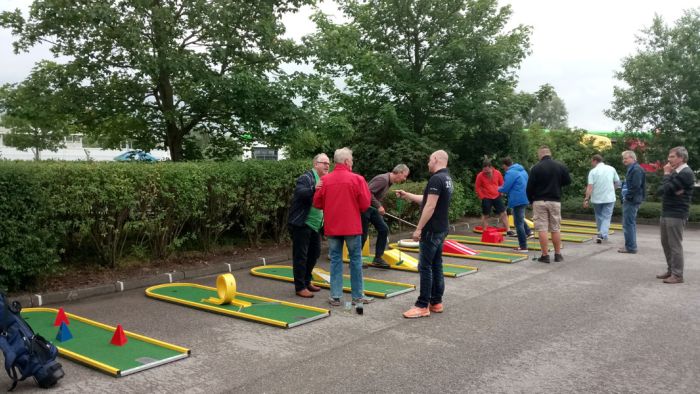 Gäste einer Firmenfeier beim Minigolfspielen