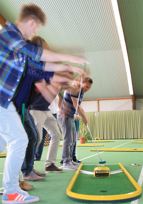 Minigolfball und Schläger auf einer mobilen Bahn