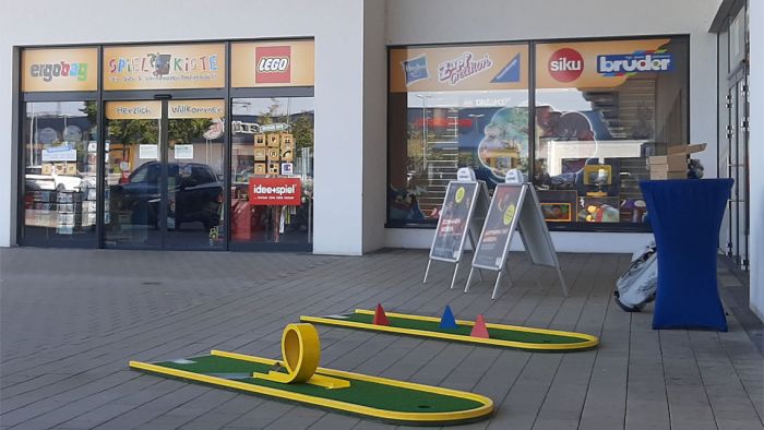 Minigolfbahn vor einem Ladengeschäft